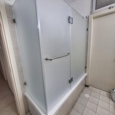 מקלחון עם דלתות זכוכית חלבית ומוט אחיזה מתכת