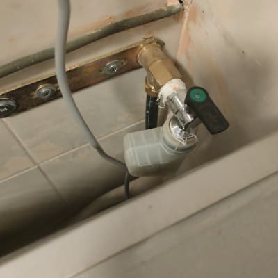 ברז פליז עם ידית שחורה וצינור מחובר