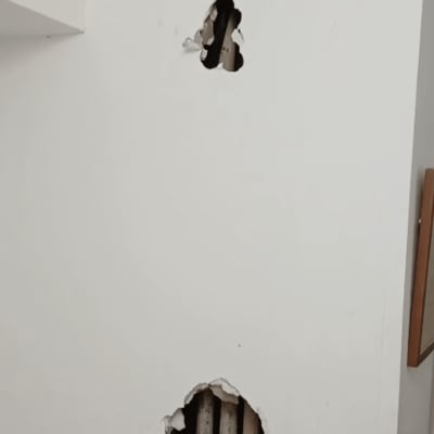 קיר עם חורים וצינורות חשופים