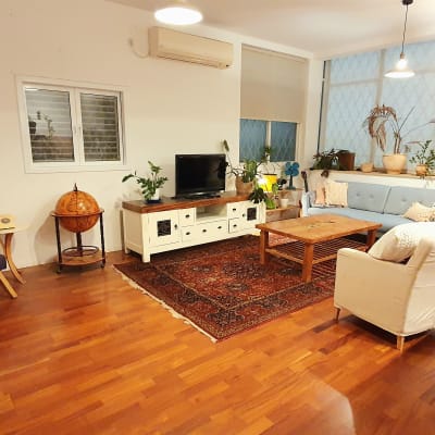 סלון עם ספה, כורסה, שולחן עץ וצמחים