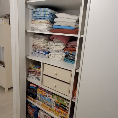 ארון עם מדפים מסודרים, בגדים ומשחקים מאורגנים