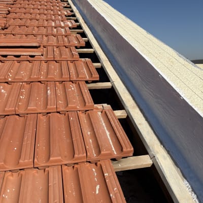 רעפים אדומים על גג עם קורות עץ חשופות