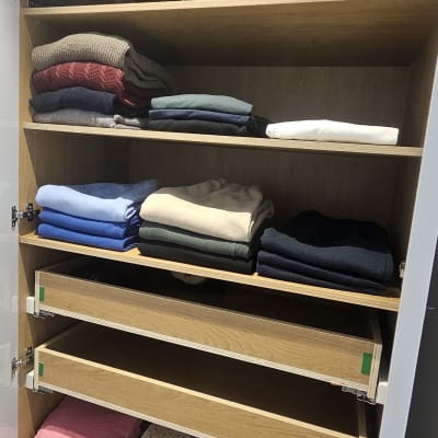 ארון בגדים מסודר עם מדפים פתוחים ובגדים מקופלים