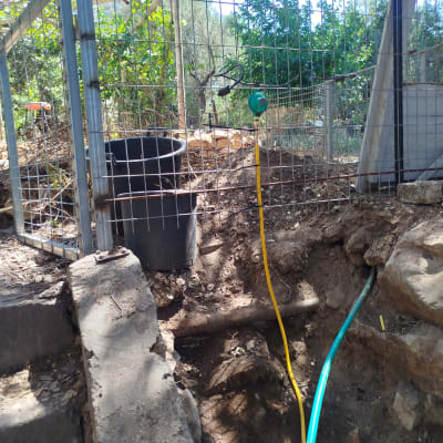 צינורות צבעוניים ליד גדר מתכת בגינה