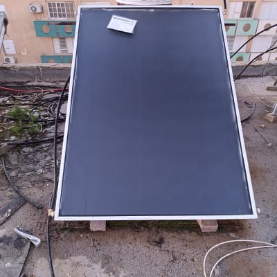 קולטי שמש על גג עם דודי שמש ברקע