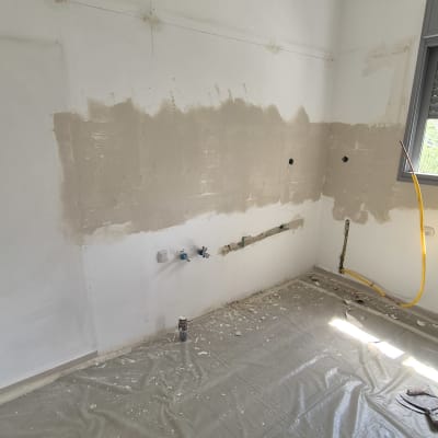 קיר עם טיח טרי, יריעות פלסטיק על הרצפה