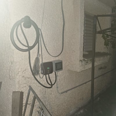 מטען חשמלי מותקן על קיר חיצוני עם כבלים