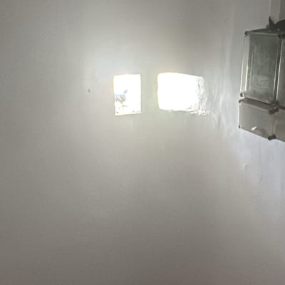 קיר עם שני חלונות קטנים וציפור מבחוץ