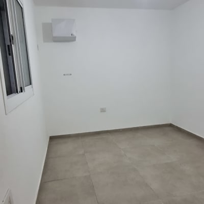 חדר ריק עם קירות לבנים ורצפת אריחים