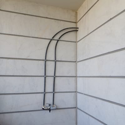 צינורות מים מחוברים לברז על קיר חיצוני