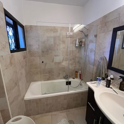 מקלחת עם אמבטיה, וילון זכוכית ומוצרי טיפוח