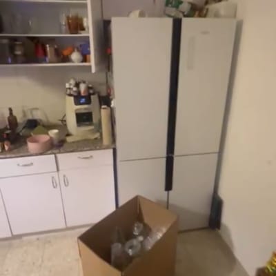 ארגזים במטבח עם מקרר וארונות פתוחים