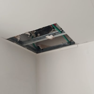 תקרת גבס פתוחה עם צינורות ירוקים ומבנה מתכת