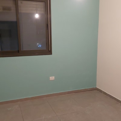 קיר צבוע בצבע תכלת עם חלון ונורה תלויה