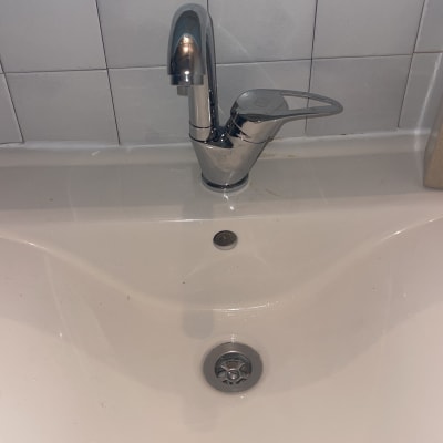 ברז כרום מעל כיור לבן עם ניקוז