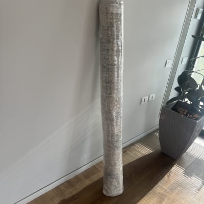 שטיח מגולגל עטוף בניילון מונח על הרצפה ליד קיר