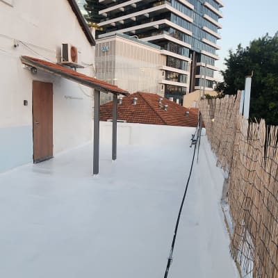 גג אטום עם שכבת איטום לבנה ומעקה עץ