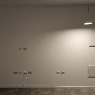 קיר צבוע בלבן עם תאורה עליונה