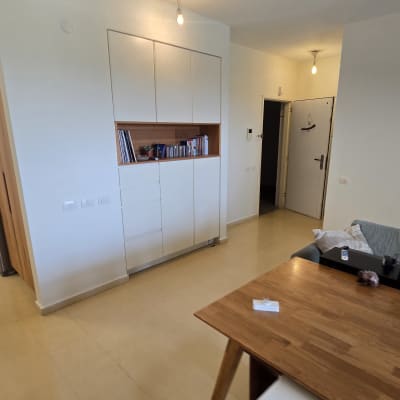 חדר עם ארון קיר, שולחן עץ וספרים על מדף