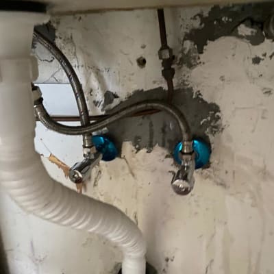 צינורות מתכת וברזים מתחת לכיור