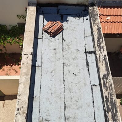 גג שטוח עם יריעות ביטומניות וערימת רעפים
