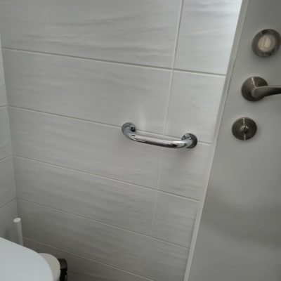 ידית אחיזה מותקנת על קיר אריחים בחדר אמבטיה