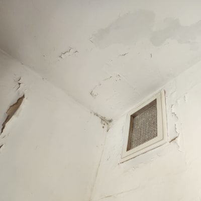 קיר מתקלף עם סדקים ופתח אוורור