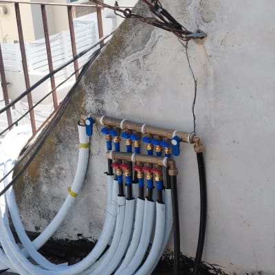 צנרת מים על קיר חיצוני עם ברזים וצינורות
