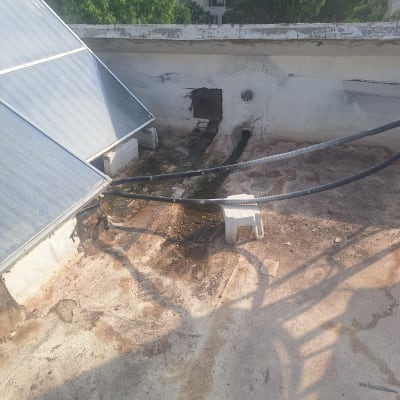 גג עם לוחות סולאריים וצינורות, סימני איטום נראים לעין