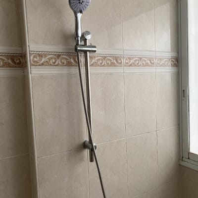 מקלחת עם ראש מקלחת על קיר אריחים