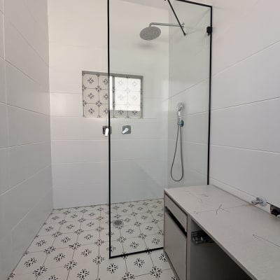 מקלחת עם דלת זכוכית ורצפת אריחים מעוצבת