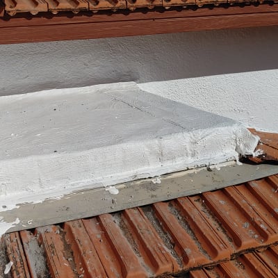 איטום גג עם חומר לבן על רעפים אדומים