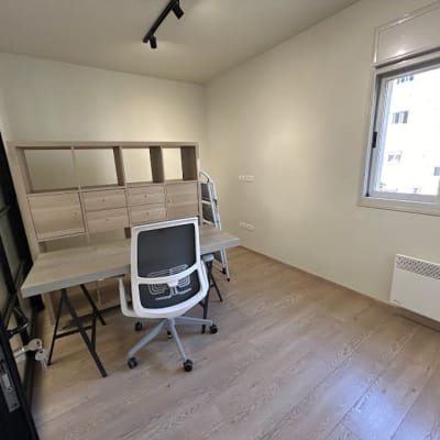 חדר עם שולחן, כיסא ומדפים מעץ