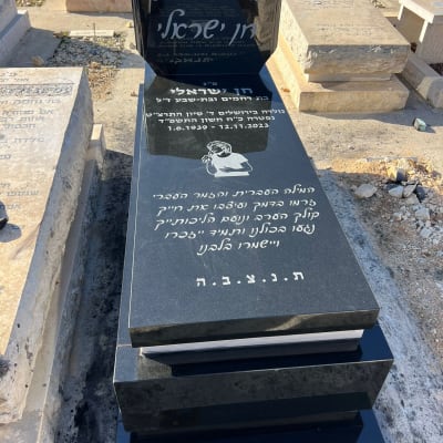 מצבה שחורה עם כיתוב בעברית בבית קברות