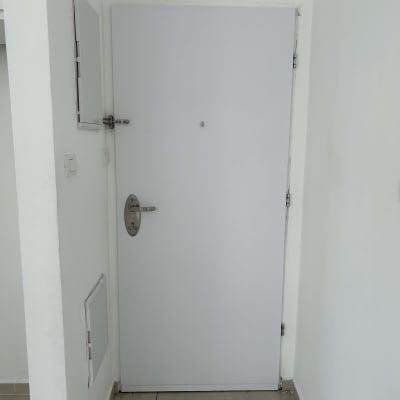 דלת לבנה עם ידית מתכת ומנעול