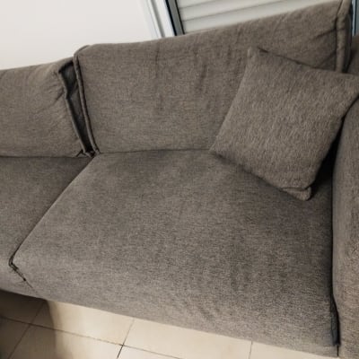 ספה אפורה עם כרית על רצפת אריחים