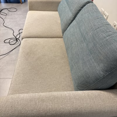 ספה עם ריפוד כחול ואפור, כבלים על הרצפה