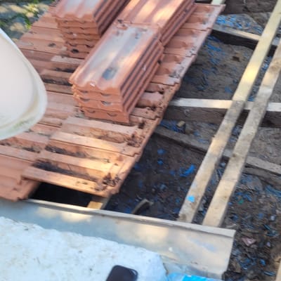 ערימות רעפים על גג בבנייה עם קורות עץ