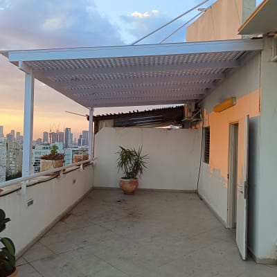 פרגולה מאלומיניום על מרפסת עם נוף עירוני