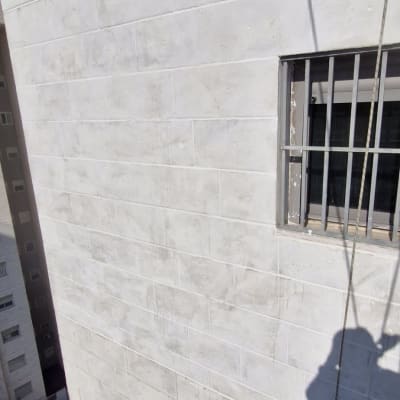 קיר בניין עם חלון וסורג, צל אדם על הקיר