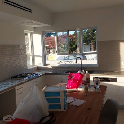 מטבח בשיפוץ עם כלים על השיש והאי