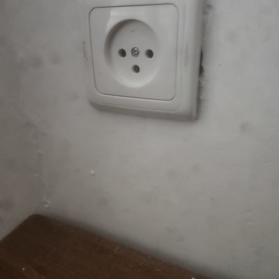 שקע חשמל בקיר לבן עם שולחן עץ