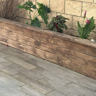 עציצים מעץ עם צמחים ירוקים ופרחים צבעוניים