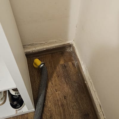 צינור גמיש עם פקק צהוב על רצפה רטובה