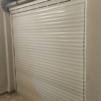 תריס גלילה לבן סגור עם מנגנון מתכת עליון