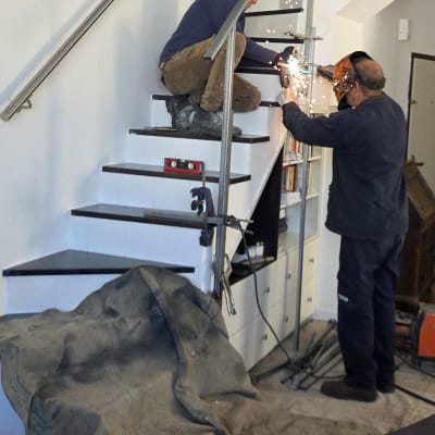 שני אנשים עובדים על מדרגות עם מסגרת מתכת