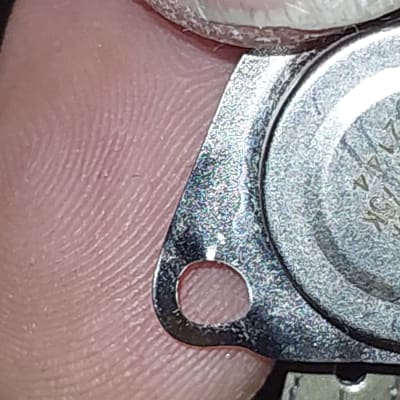 רכיב מתכתי קטן מוחזק בין אצבעות