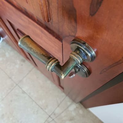 ידית דלת מתכתית על דלת עץ