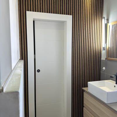 דלת לבנה עם ידית עגולה בקיר עץ