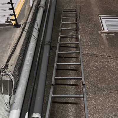 סולם מתכת צמוד לקיר עם צינורות חשמל